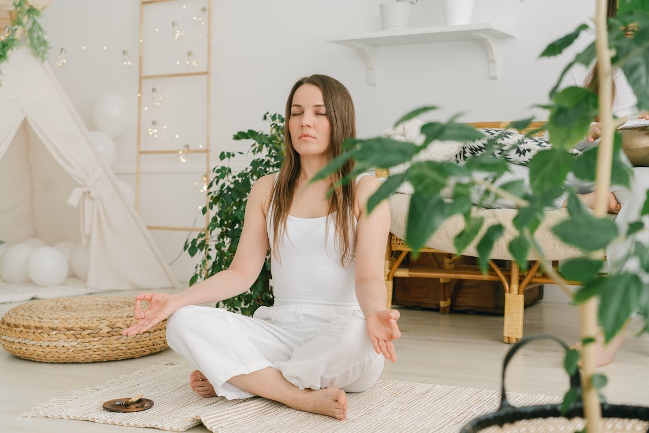 gallery-06 Peaceful meditation scene with a woman practicing mindfulness in a cozy, plant-filled indoor space.